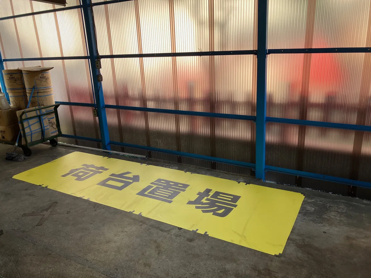 台車の置き場に設置した「荷台置場」の黄色い床置きサイン