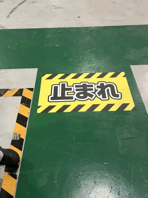 通路に設置した「止まれ」の足元表示